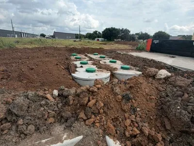 Septic tanks with green lids set in the ground at a commercial site