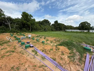 Purple drip lines and green risers running across a septic field