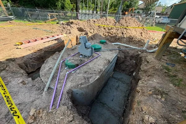 Septic tank set in an excavation with piping and caution tape