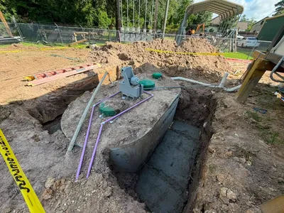 Septic tank set in an excavation with piping and caution tape