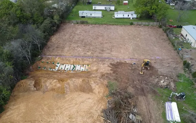 Aerial view of an excavator working on a septic drain field site