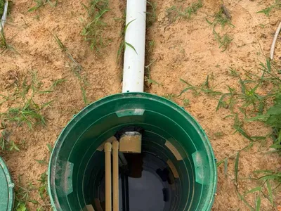 Open green riser lid showing the pump chamber of a septic system