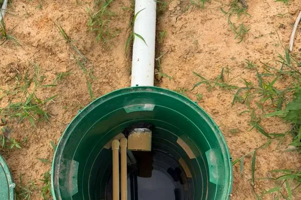 Open green riser lid showing the pump chamber of a septic system