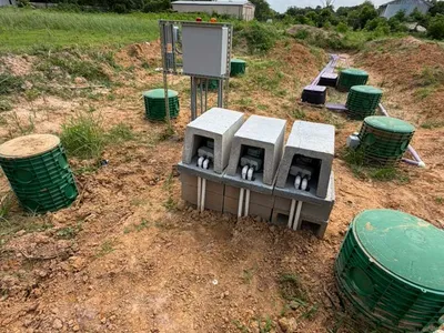 Septic control boxes and green risers on a cleared field