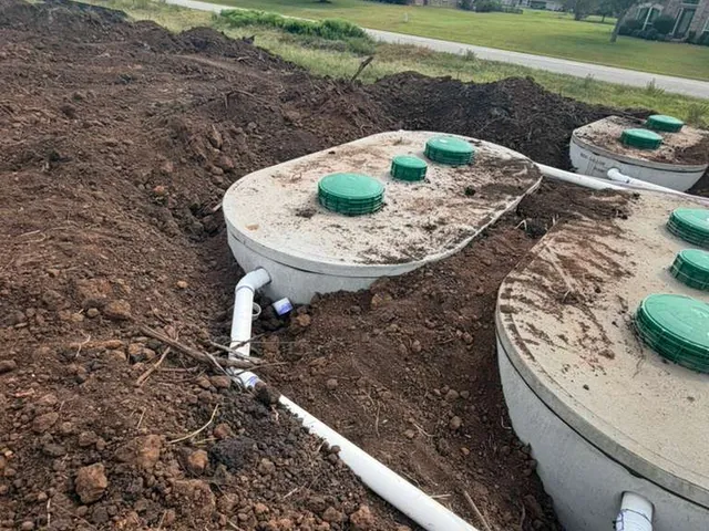 Septic tanks with green lids and white piping at a new development