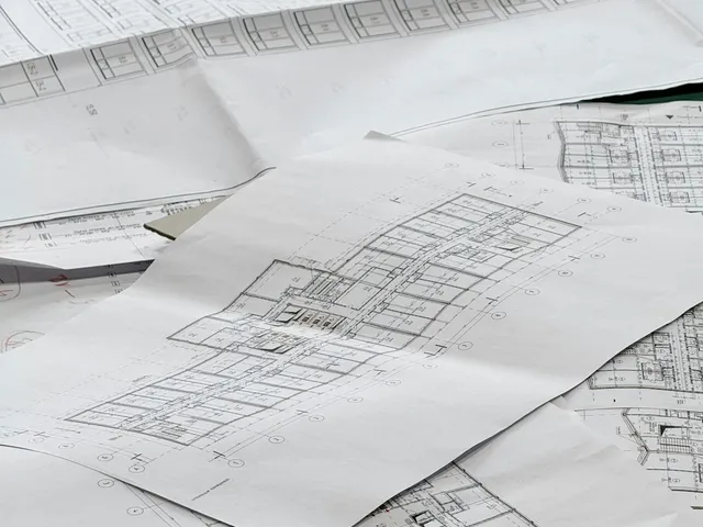 Engineering blueprints spread on a table for a septic system design