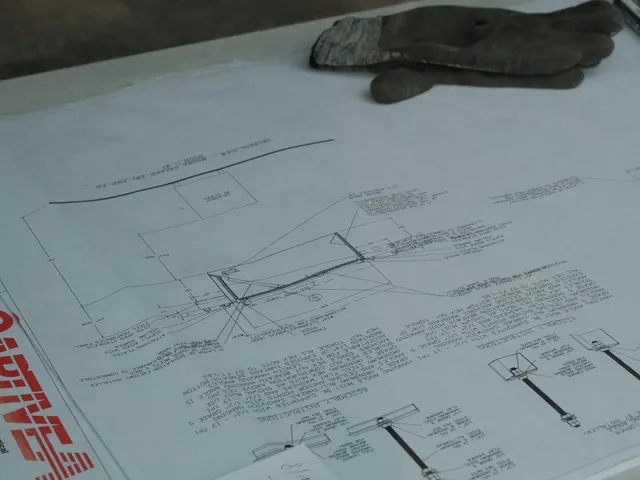 Technical drawings and a permit seal on a table, representing septic permit paperwork